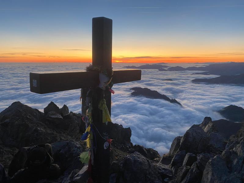 Croix au sommet des Pyrénées, mer de nuages au coucher de soleil